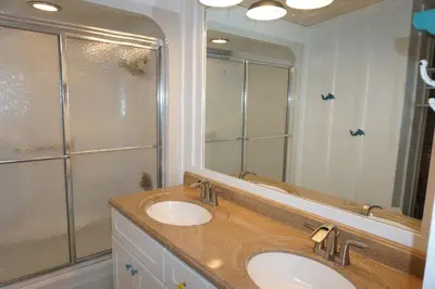 a bathroom with a sink and a large mirror at Venture Out 41 Gulf Loop 2bd 1ba WITH GOLF CART in Panama City Beach