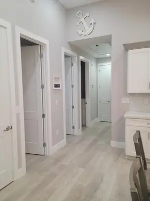 a living room with white walls and wooden floors at Venture Out 600 Seabreeze Dr Comes WITH GOLF CART in Panama City Beach