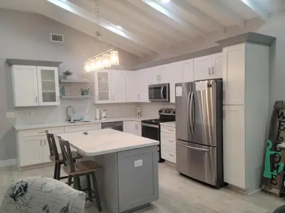 a kitchen with white cabinets and a stainless steel refrigerator at Venture Out 600 Seabreeze Dr Comes WITH GOLF CART in Panama City Beach
