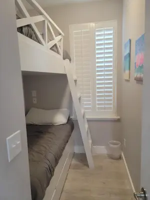 a bunk bed in a room with a bunk bed under a ladder at Venture Out 600 Seabreeze Dr Comes WITH GOLF CART in Panama City Beach