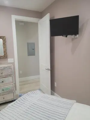 a bedroom with a bed and a tv on the wall at Venture Out 600 Seabreeze Dr Comes WITH GOLF CART in Panama City Beach