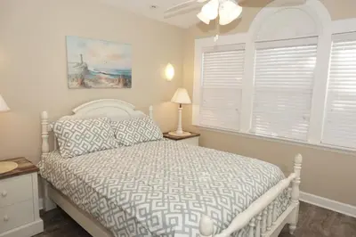 a bedroom with a white bed and a window at Venture Out 476 Marlin Dr Comes WITH GOLF CART in Panama City Beach