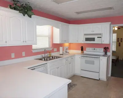 a kitchen with white cabinets and white appliances at Venture Out 402 North Marlin Dr WITH GOLF CART in Panama City Beach