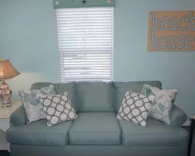 a blue couch with pillows on it in a living room at Venture Out 402 North Marlin Dr WITH GOLF CART in Panama City Beach