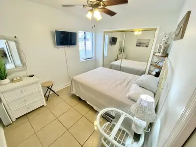 a bedroom with a bed and a mirror at Venture Out 332 Lagoon Ln WITH 2 GOLF CARTS in Panama City Beach