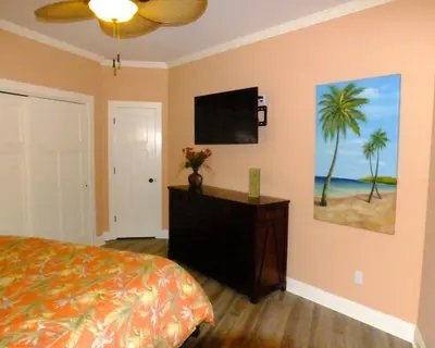 a bedroom with a bed and a flat screen tv at Venture Out 152 Gulf Loop With Golf Cart in Panama City Beach