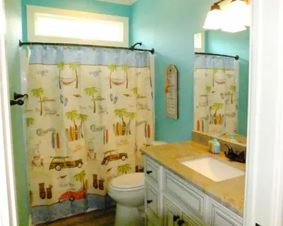 a bathroom with a shower curtain with a toilet and a sink at Venture Out 152 Gulf Loop With Golf Cart in Panama City Beach