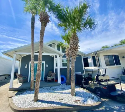 two palm trees in front of a house with a car at Venture Out 646 Octopus Dr Comes WITH GOLF CART in Panama City Beach