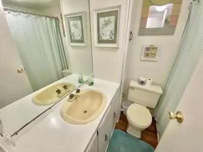 a white bathroom with a sink and a toilet at Venture Out 646 Octopus Dr Comes WITH GOLF CART in Panama City Beach