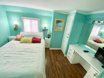 a bedroom with blue walls and a white bed at Venture Out 646 Octopus Dr Comes WITH GOLF CART in Panama City Beach