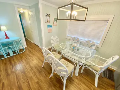 a dining room with a glass table and chairs at Venture Out 646 Octopus Dr Comes WITH GOLF CART in Panama City Beach