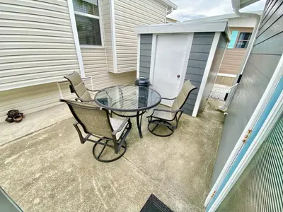 a glass table and chairs on a patio at Venture Out 646 Octopus Dr Comes WITH GOLF CART in Panama City Beach
