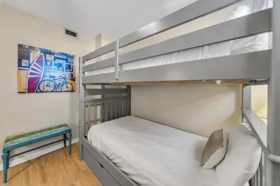 a bedroom with two bunk beds and a couch at Aquavista 504W in Panama City Beach