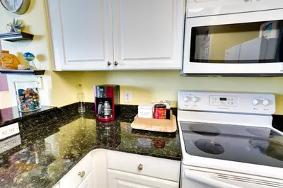 a kitchen with a stove and a microwave at PCB Condo with Resort Amenities and Ocean Views in Panama City Beach