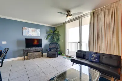 a living room with a couch and a television at PCB Condo with Resort Amenities and Ocean Views in Panama City Beach