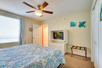 a bedroom with a bed and a flat screen tv at PCB Condo with Resort Amenities and Ocean Views in Panama City Beach