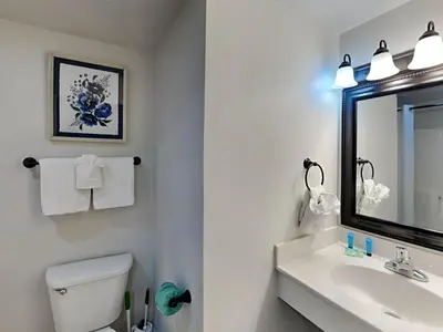 a bathroom with a sink and a toilet and a mirror at Shores of Panama #1330 in Panama City Beach