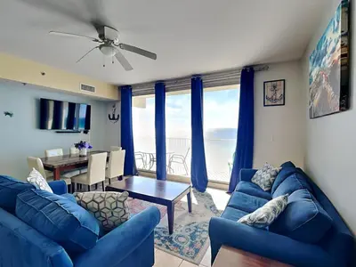 a living room with a blue couch and a table at Shores of Panama #1330 in Panama City Beach