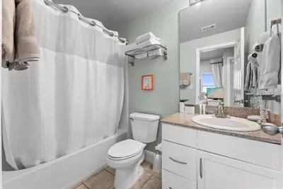 a white bathroom with a toilet and a sink at Beach & Ocean Views! Steps to Beach & Dining, Sleeps 9! Dolce Vita Getaways PCB in Panama City Beach