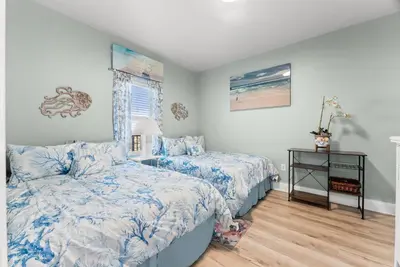 a bedroom with two beds with blue comforter at Beach & Ocean Views! Steps to Beach & Dining, Sleeps 9! Dolce Vita Getaways PCB in Panama City Beach