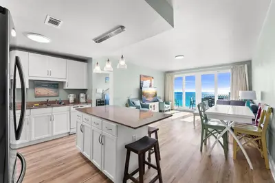 a kitchen and living room with a table and a dining room at Beach & Ocean Views! Steps to Beach & Dining, Sleeps 9! Dolce Vita Getaways PCB in Panama City Beach