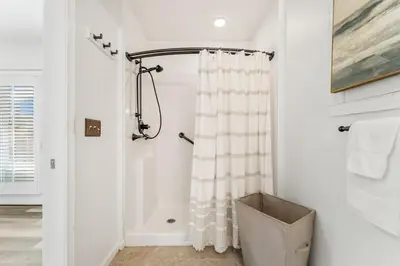a bathroom with a shower with a white shower curtain at 4BD Resort Home Golf Cart Inc 11 Pools in Panama City Beach