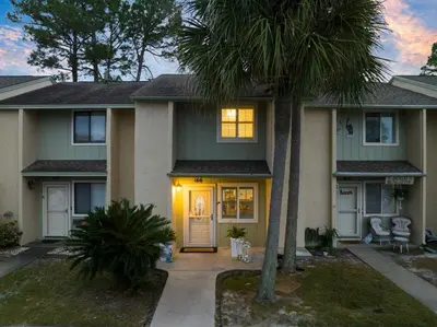 a house with palm trees in front of it at 4BD Resort Home Golf Cart Inc 11 Pools in Panama City Beach