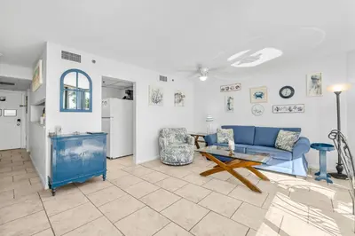 a living room with a blue couch and a table at 1st Floor Resort Condo! No Elevators! Free Beach Chair Service! by Dolce Vita Getaways PCB in Panama City Beach