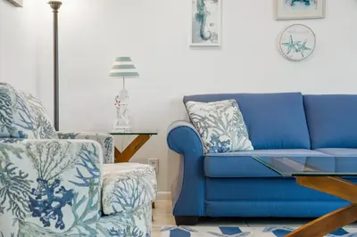 a blue couch and a chair in a living room at 1st Floor Resort Condo! No Elevators! Free Beach Chair Service! by Dolce Vita Getaways PCB in Panama City Beach