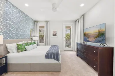 a bedroom with a bed and a dresser with a television at 30A Beach House - Beach Ball by Panhandle Getaways in Inlet Beach