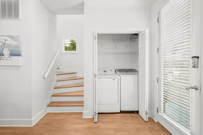 a laundry room with a washer and dryer and a staircase at 30A Beach House - Beach Ball by Panhandle Getaways in Inlet Beach