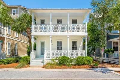 a white house with a balcony and palm trees at 30A Beach House - Beach Ball by Panhandle Getaways in Inlet Beach