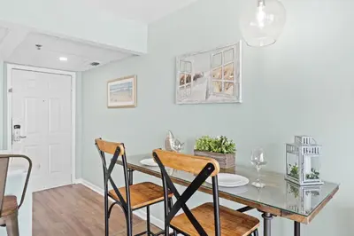a dining room with a glass table and chairs at Long Beach Resort 302 Tower 2 By Book That Condo in Panama City Beach