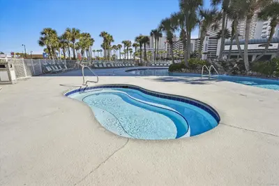 a swimming pool with blue water and palm trees at Long Beach Resort 302 Tower 2 By Book That Condo in Panama City Beach