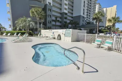 a hot tub in a pool with chairs and buildings at Long Beach Resort 302 Tower 2 By Book That Condo in Panama City Beach