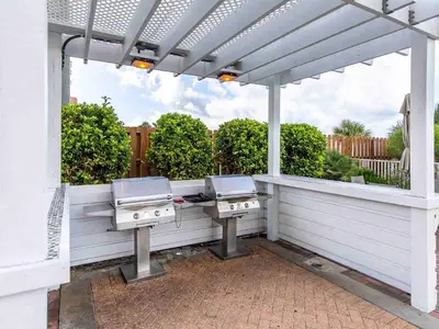 a pergola with two bbqurgers on a patio at Twin Palms #1501A in Panama City Beach