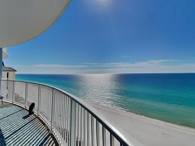 a person sitting on a balcony looking at the ocean at Twin Palms #1501A in Panama City Beach