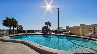 a large swimming pool with the sun in the sky at Fun N The Sun at Sunbird #1102W by InJoy Vacations in Panama City Beach