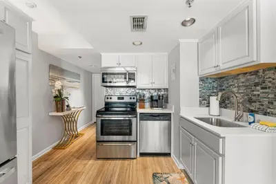 a kitchen with white cabinets and a stainless steel stove at Fun N The Sun at Sunbird #1102W by InJoy Vacations in Panama City Beach