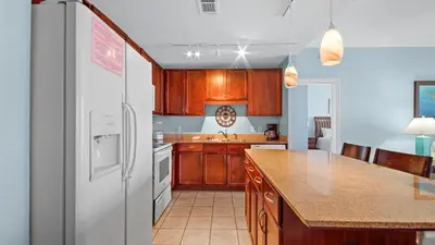 a kitchen with wooden cabinets and a white refrigerator at Laketown Wharf #1025 in Panama City Beach