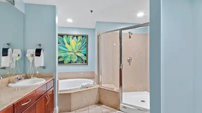 a bathroom with a tub and a sink and a shower at Laketown Wharf #1025 in Panama City Beach