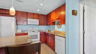 a kitchen with wooden cabinets and white appliances at Laketown Wharf #1025 in Panama City Beach