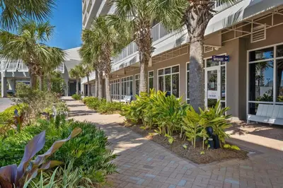 a walkway in front of a building with palm trees at Laketown Wharf #1115 in Panama City Beach