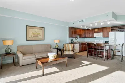 a living room with a couch and a table and a kitchen at Laketown Wharf #1115 in Panama City Beach