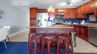 a kitchen with wooden cabinets and a island with stools at Laketown Wharf #1537 in Panama City Beach