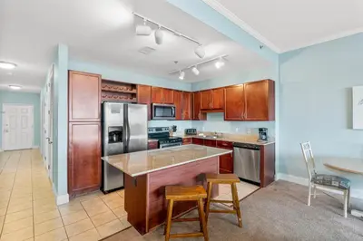 a kitchen with wooden cabinets and a table and chairs at Laketown Wharf #2133 in Panama City Beach