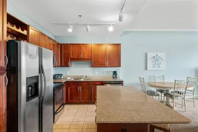 a kitchen with wooden cabinets and a stainless steel refrigerator at Laketown Wharf #2133 in Panama City Beach