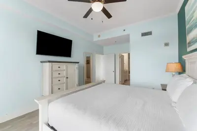a bedroom with a white bed and a flat screen tv at Laketown Wharf #2030 in Panama City Beach