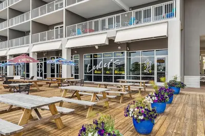 a patio with picnic tables and flowers in front of a building at Laketown Wharf #2030 in Panama City Beach