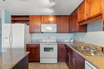a kitchen with wooden cabinets and a white stove top oven at Laketown Wharf #0811 in Panama City Beach